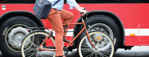 Une personne en velo à côté d'un autobus