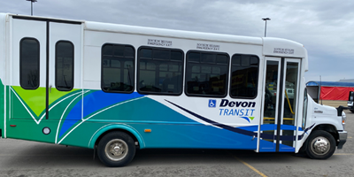 Autobus stationné de couleur verte, bleue et blanche.