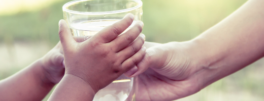 Des mains qui tiennent un verre d'eau