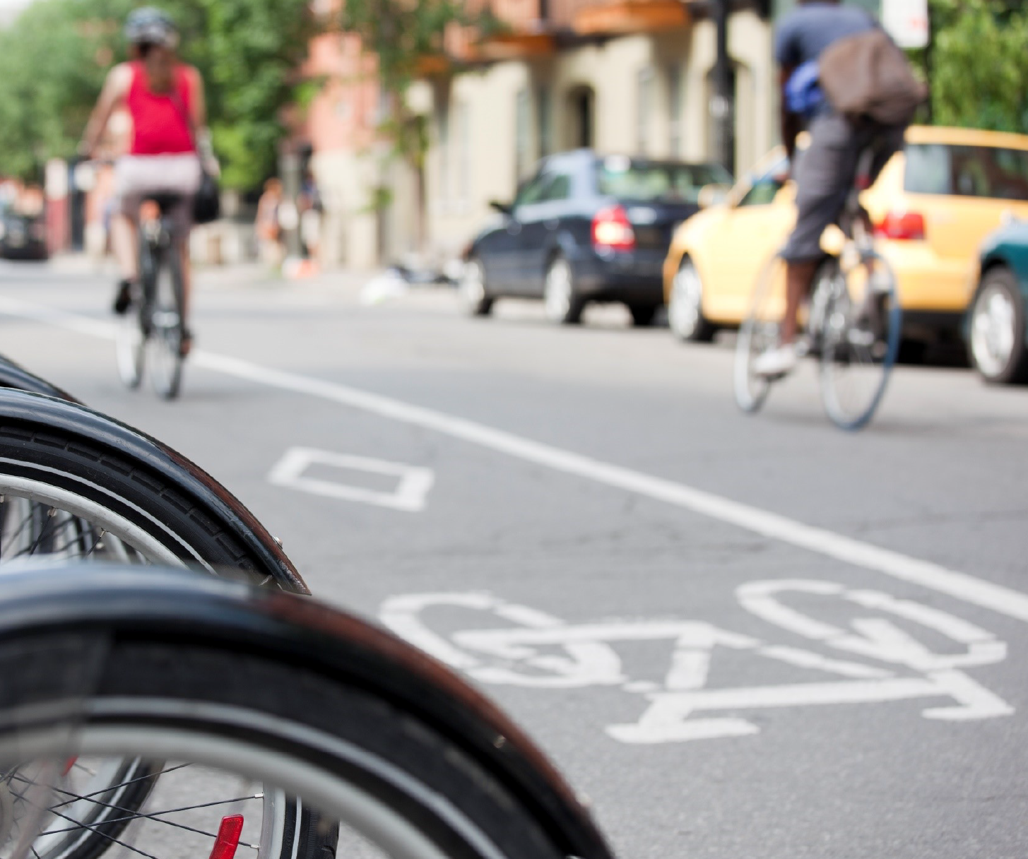 Système public de vélopartage avec deux cyclistes en arrière-plan. 