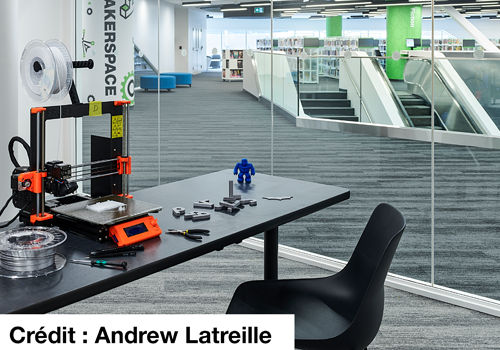 Espace de travail avec une personne à un bureau utilisant des outils sous une lampe grossissante