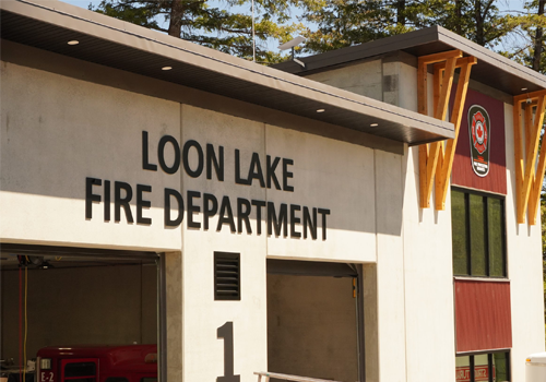 Loon Lake Fire Department 1 écrit en grosses lettres sur la surface extérieure d’une caserne de pompiers.