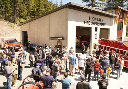 Un rassemblement de personnes devant une caserne de pompiers.