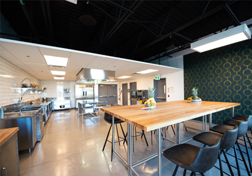 Cuisine industrielle avec des appareils en acier inoxydable et un coin salon.