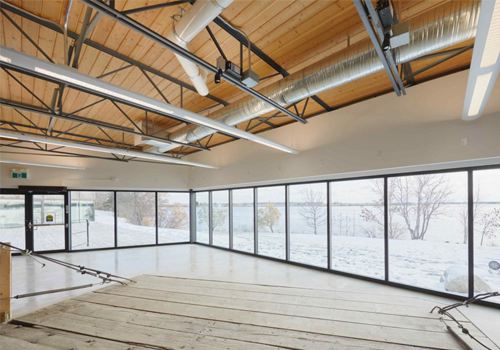 Intérieur d'un espace moderne doté de larges fenêtres et de planchers de bois.