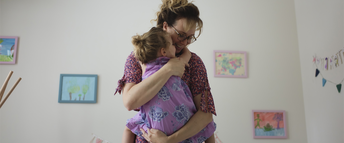 Un parent serrant son enfant dans ses bras.