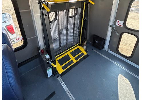 Un élévateur pour fauteuil roulant à l’intérieur d’un autobus.